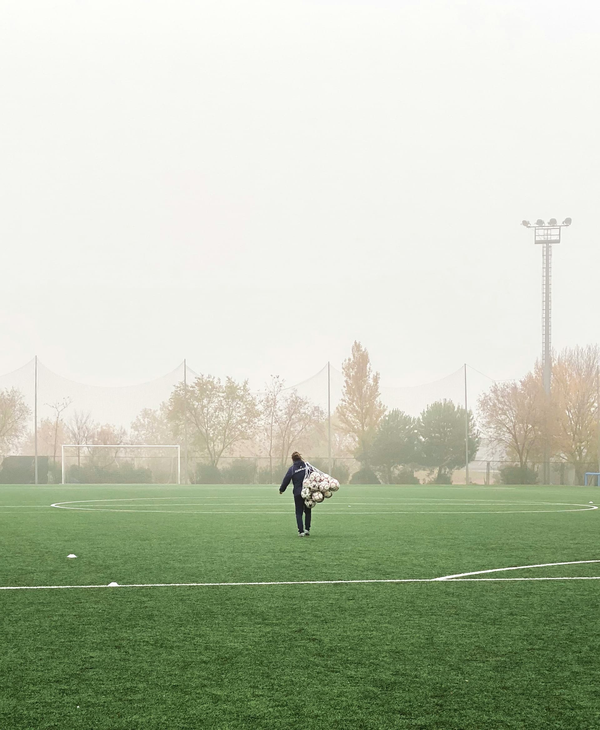 Youth soccer coach preparing training equipment